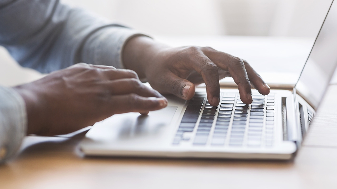 photo of a man's hands on a keyboard