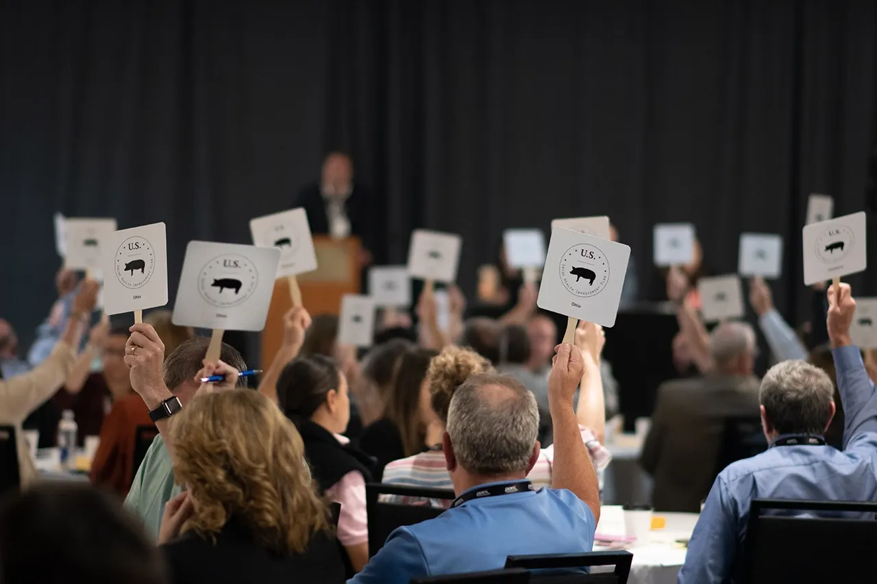 audience members holding up placards to vote at a meeting