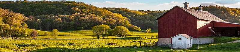 farm pasture with red barn in foreground