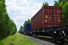 Transportation of railway cars by cargo containers shipping.