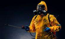 person in hazmat suit spraying disinfectant