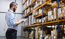 man inspecting warehouse stockpile of goods